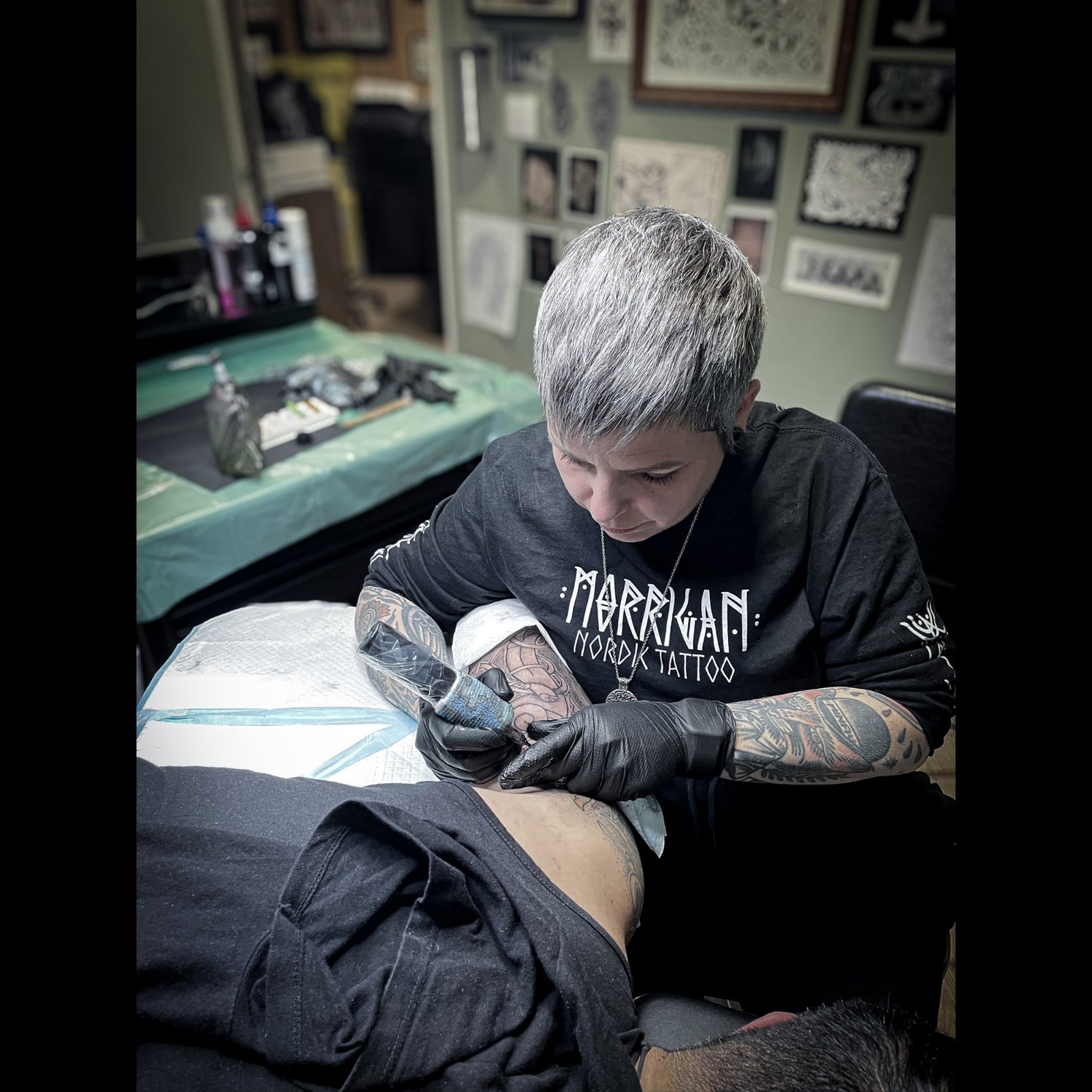 Hélène Morrigan tattooing a Norse mythology design in her private studio in France