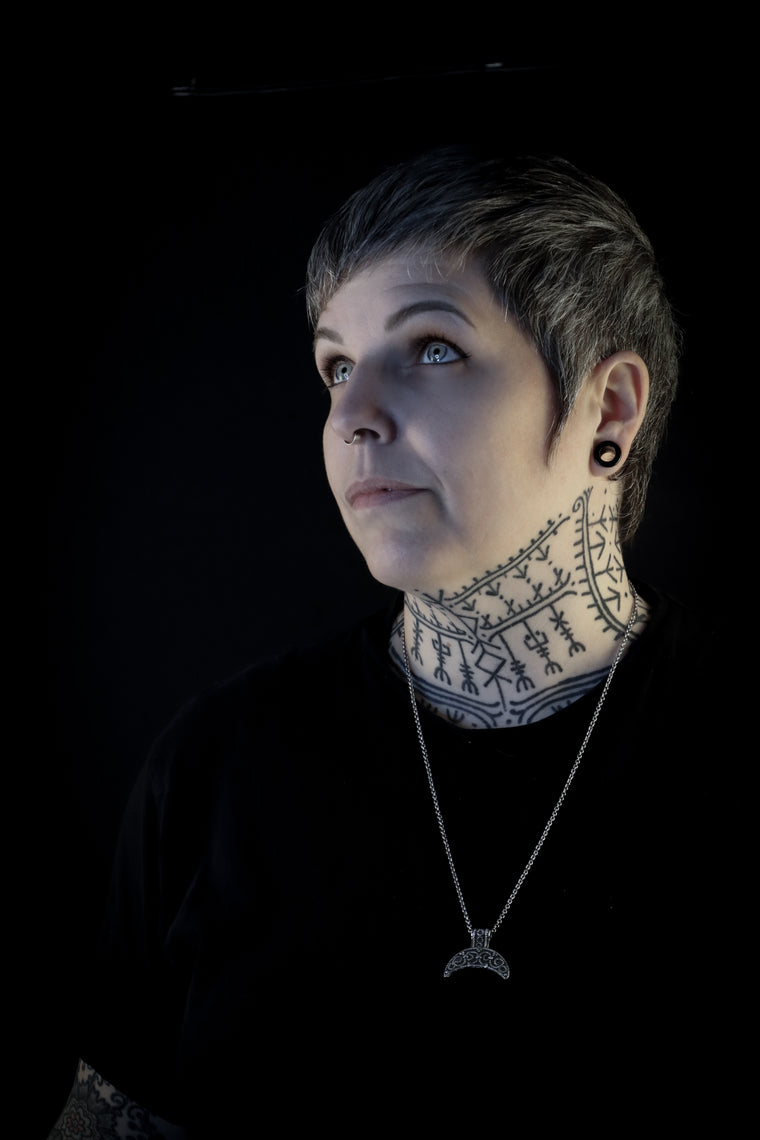 Portrait of Hélène Morrigan, Viking and Norse mythology tattoo artist wearing Nordic jewelry and runic neck tattoo