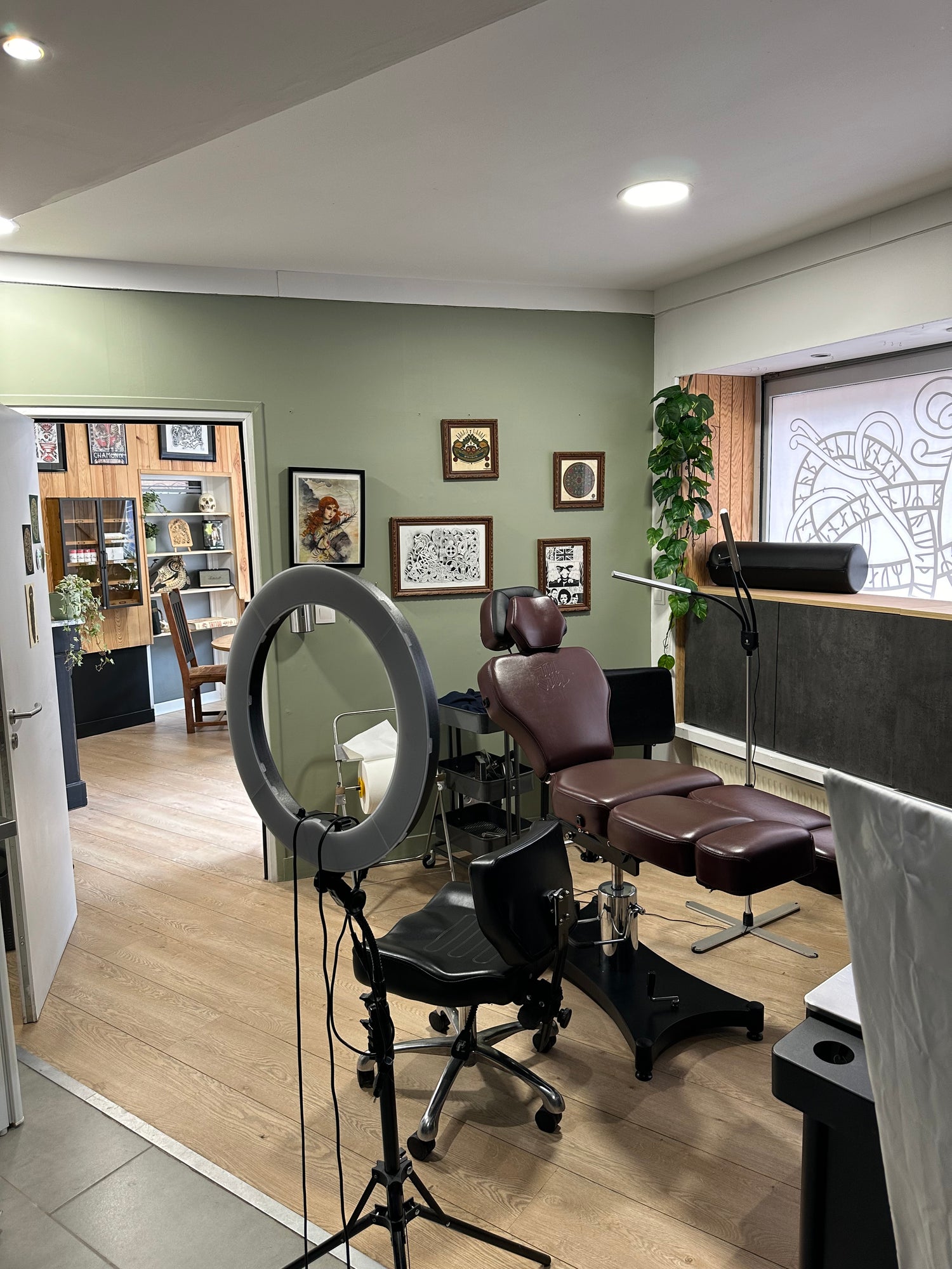 Tattoo workspace at Morrigan Tattoo studio featuring professional chair, lighting setup and Norse-inspired wall decor