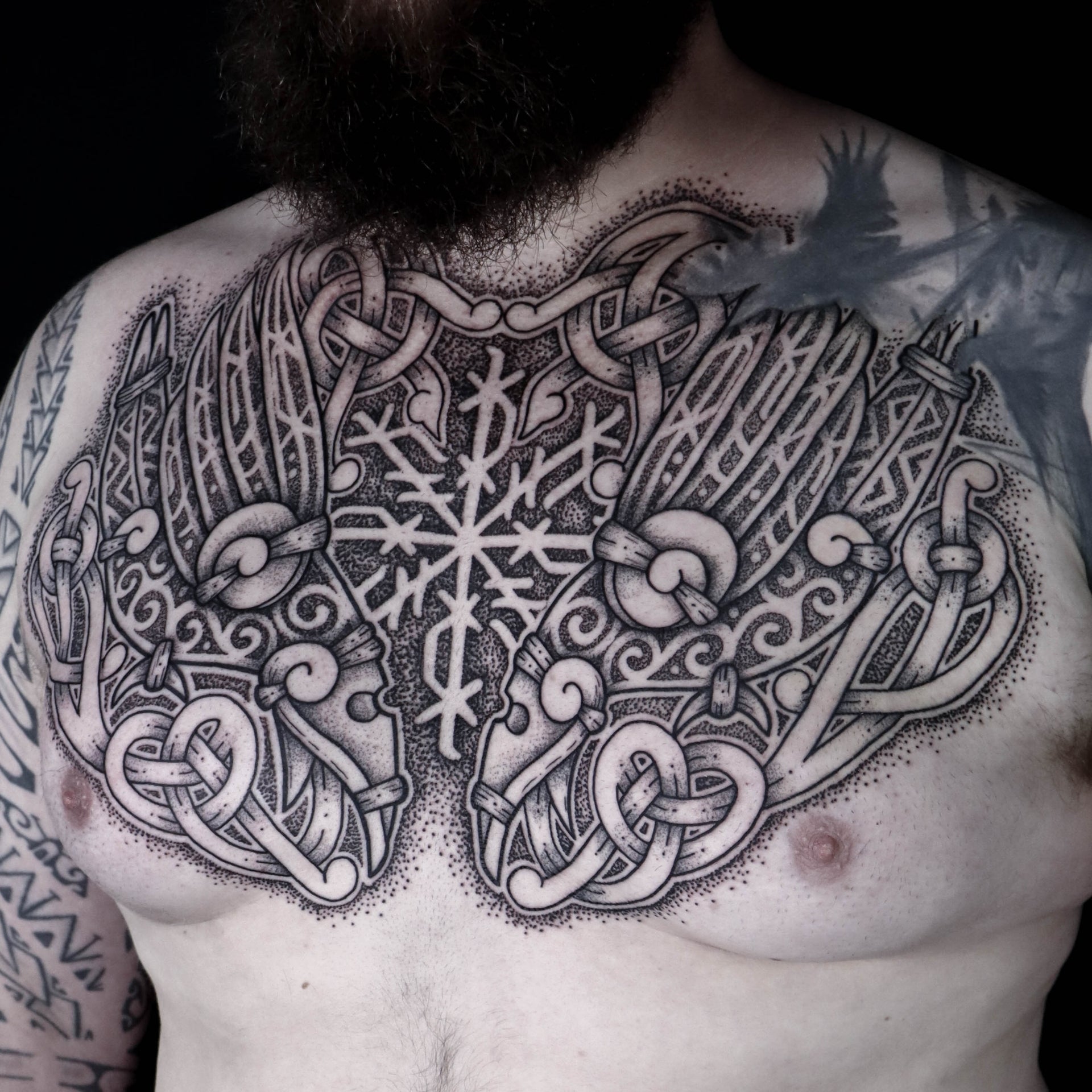 Norse mythology chest tattoo featuring Huginn and Muninn with central sigil and bindrunes by Morrigan Tattoo France