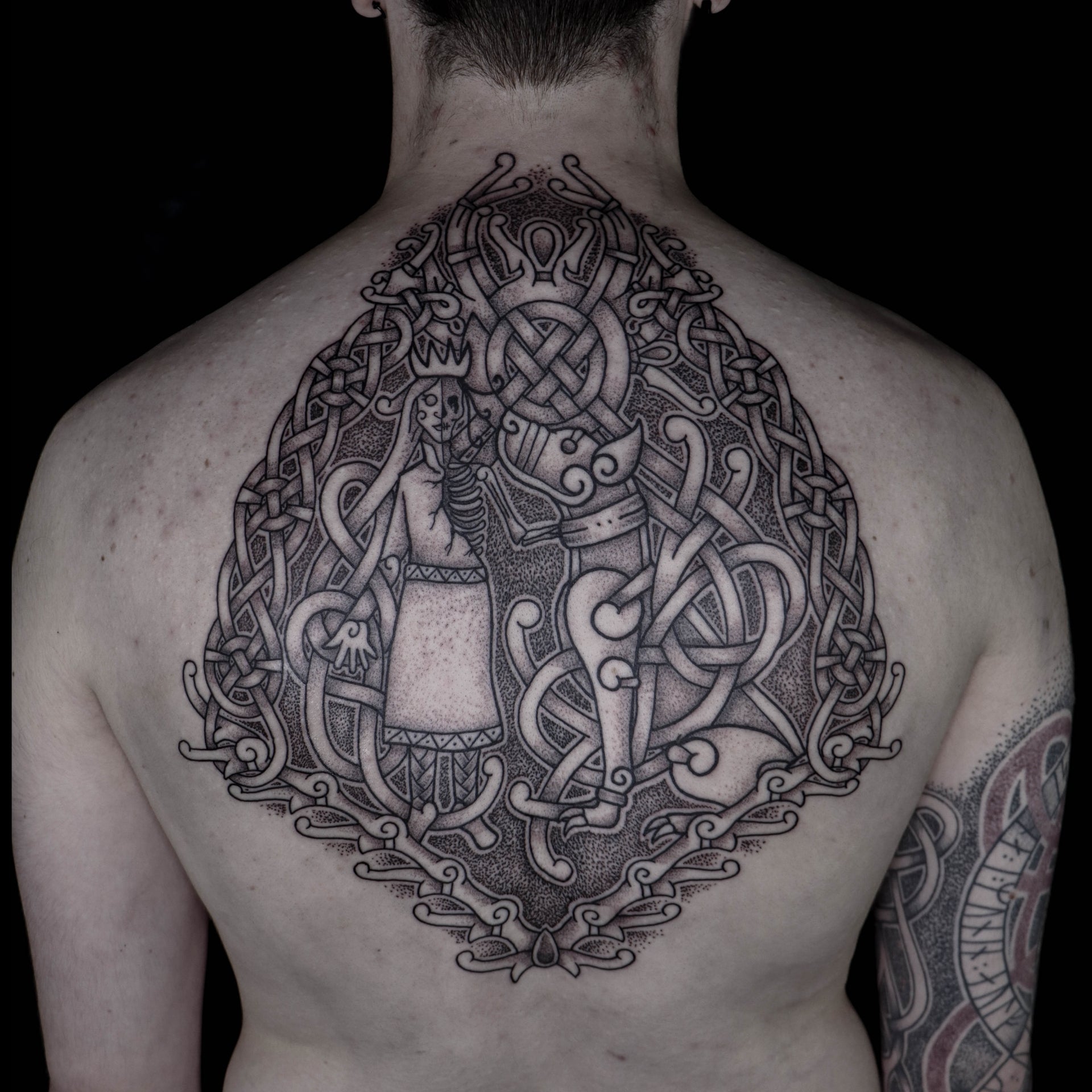 Norse backpiece tattoo depicting the goddess Hel with Garm, composed with historical knotwork patterns inspired by Scandinavian artifacts