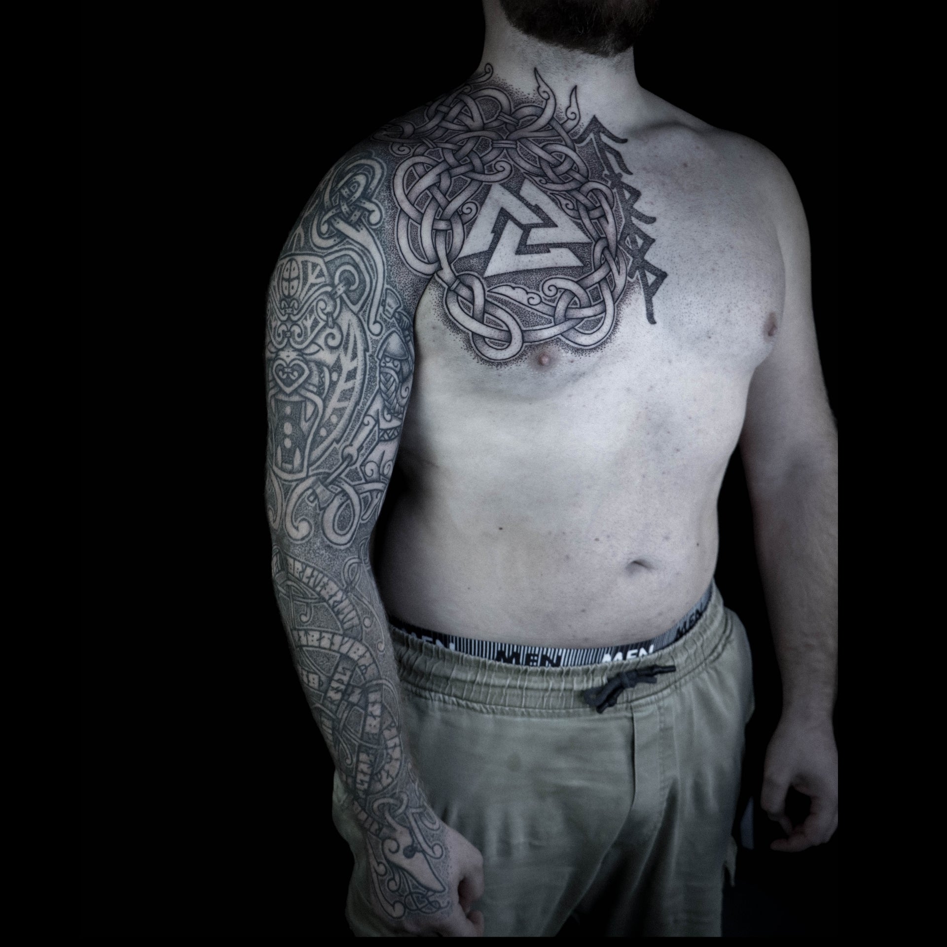 Norse sleeve and half chest tattoo featuring Jormungandr with runes, bear godmask, berserker and Valknut with interlaced bindrune design