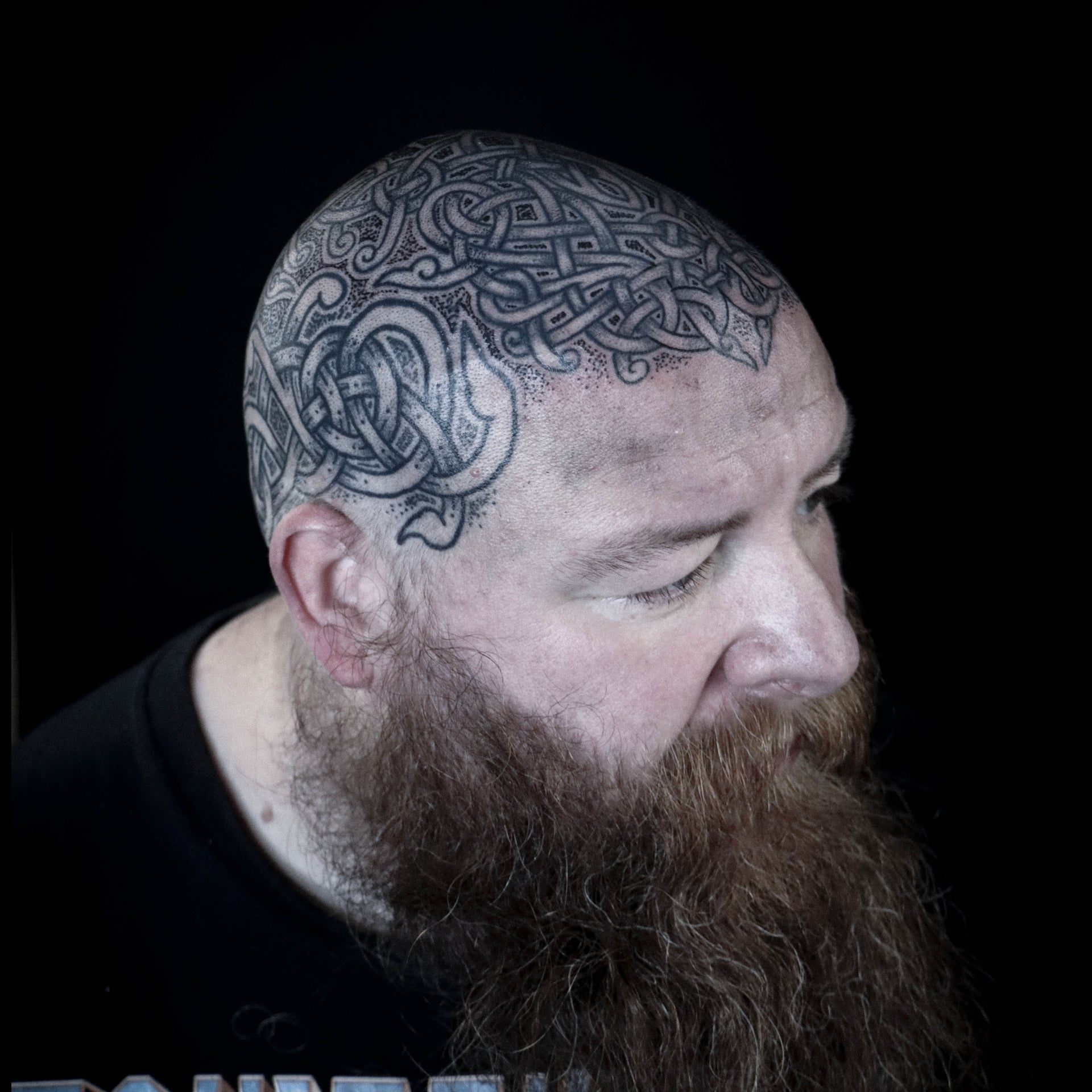 Scandinavian full head tattoo composed of intricate interlaced knotwork in dense blackwork style