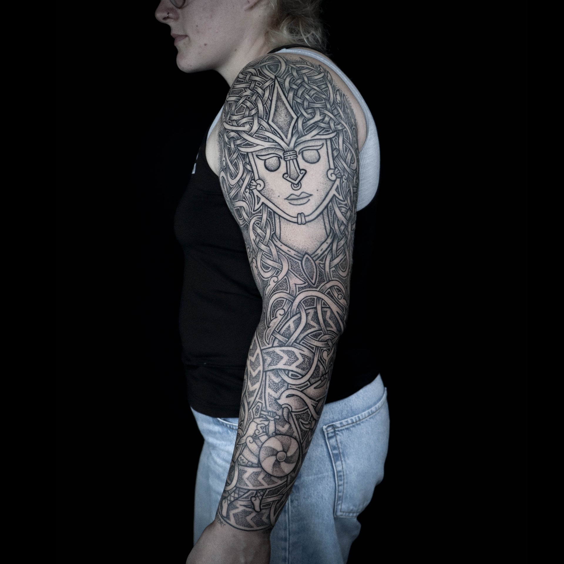Viking full sleeve tattoo featuring a Freyja godmask and Thor in battle with interlaced knotwork by Morrigan Tattoo