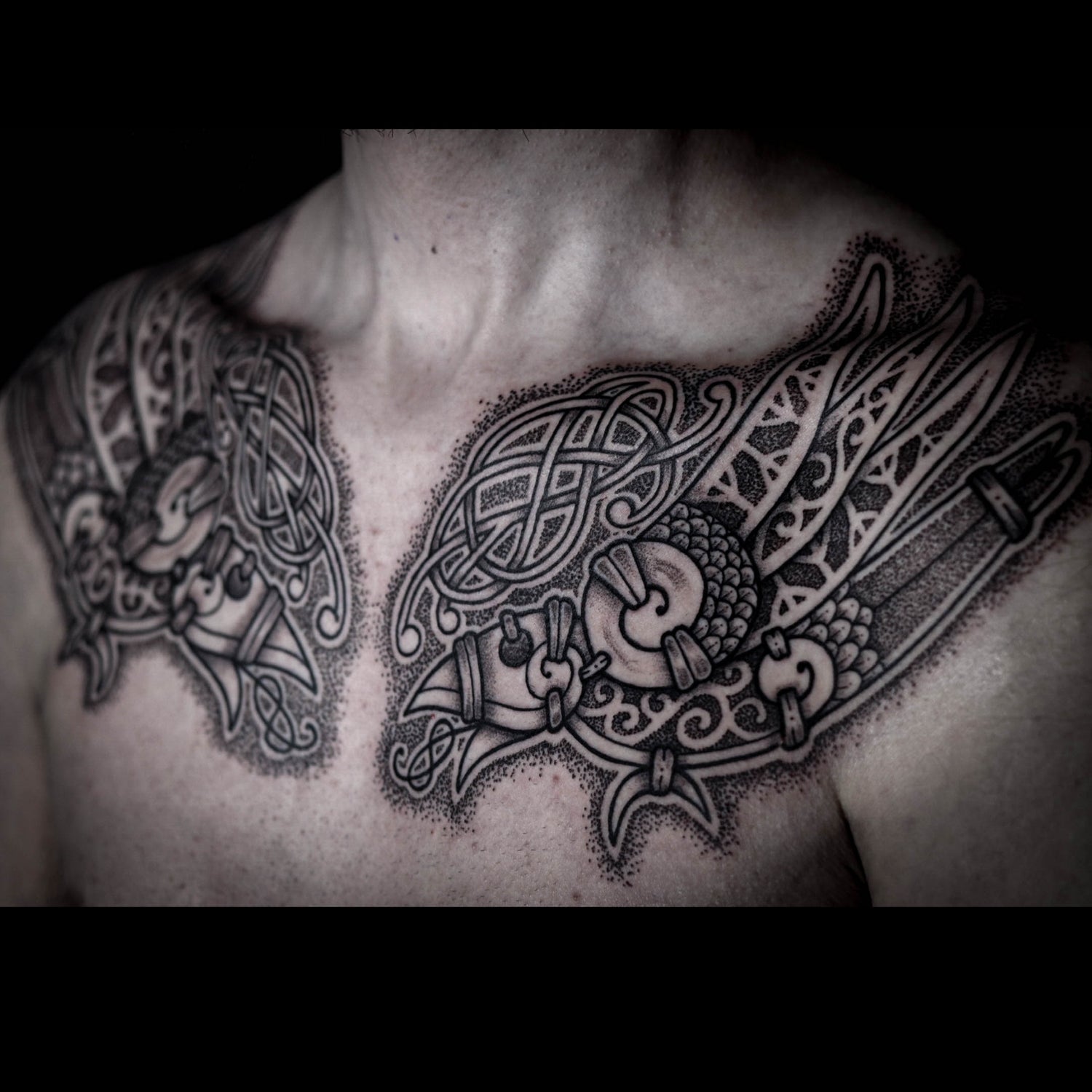 Viking mythology chest tattoo featuring Huginn and Muninn composed in intricate knotwork and detailed blackwork shading